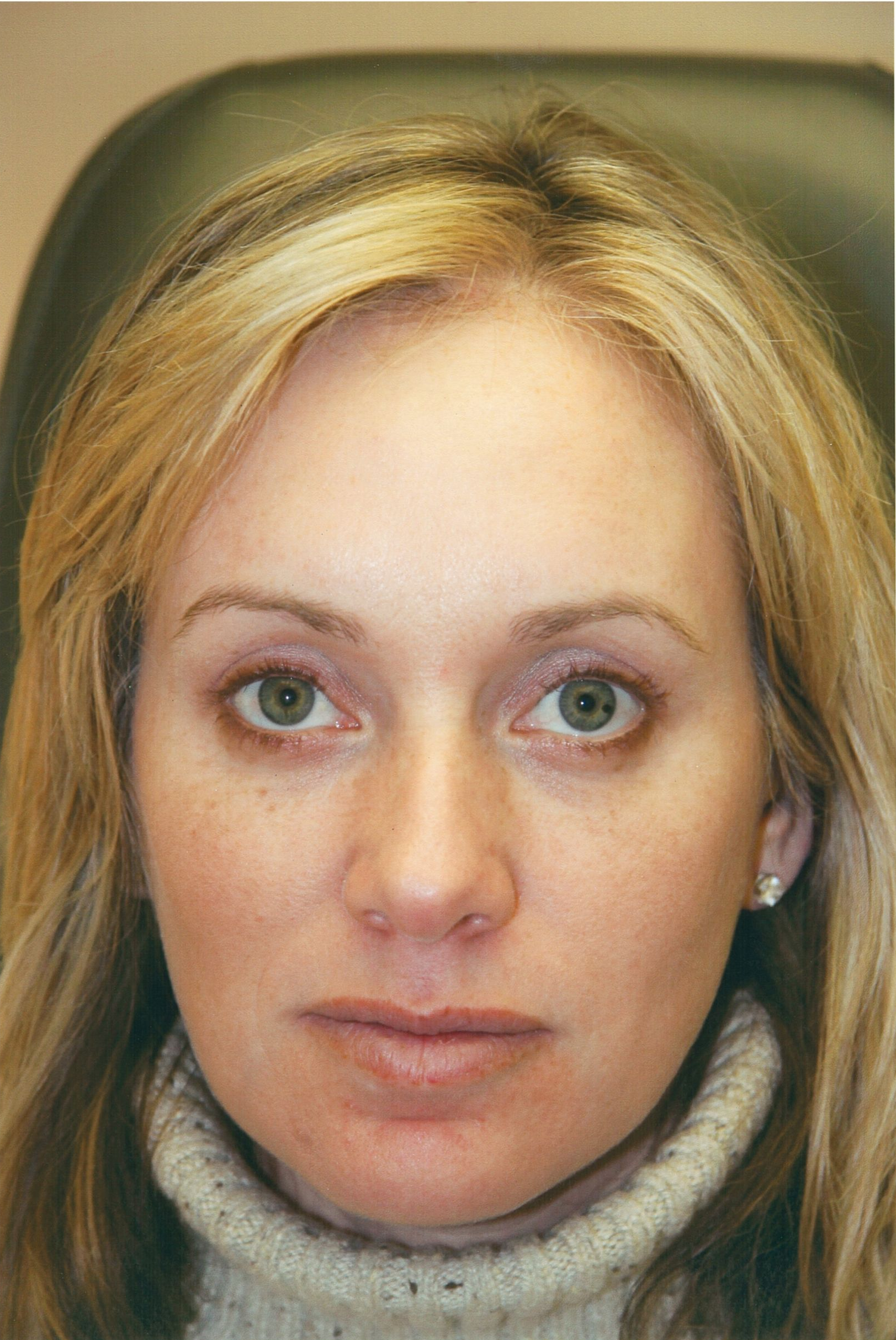 Woman with fair skin, green eyes, blonde hair, wearing a cream turtleneck; facing forward.