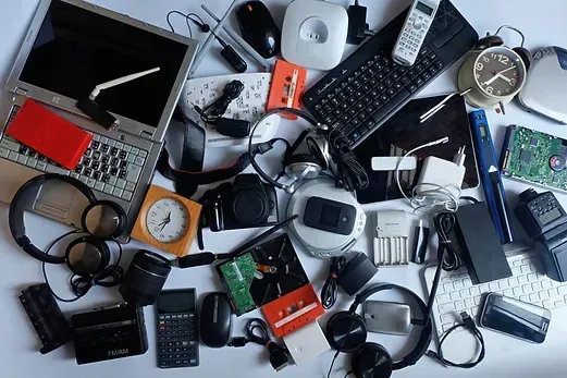 A bunch of electronic devices on a table including a laptop