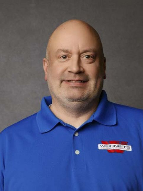 Bald man wearing a blue polo shirt with
