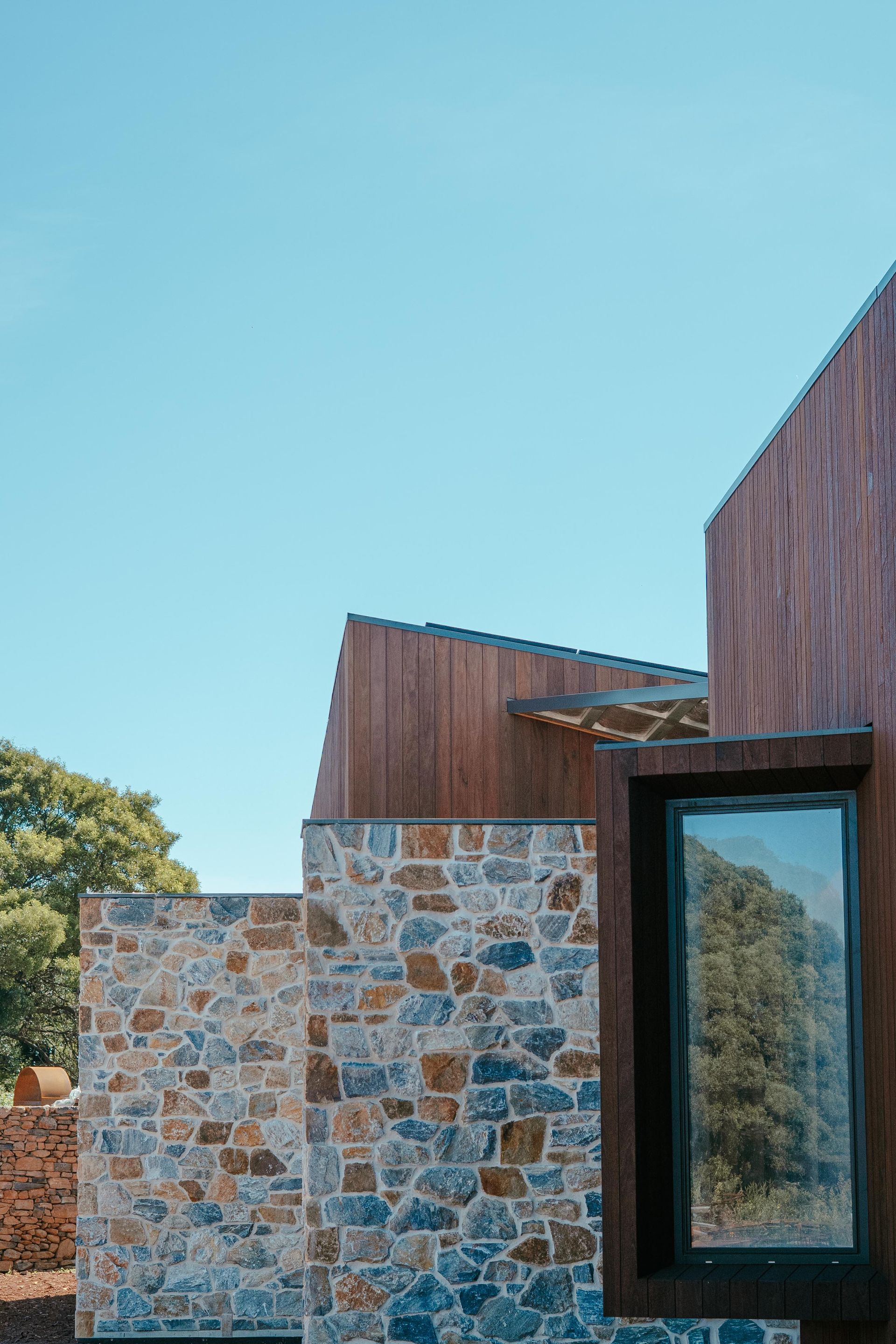 Rolled Blueprints on the Desk and a Person Was Working in the Background — Focus Building Certifiers In Bowral, NSW