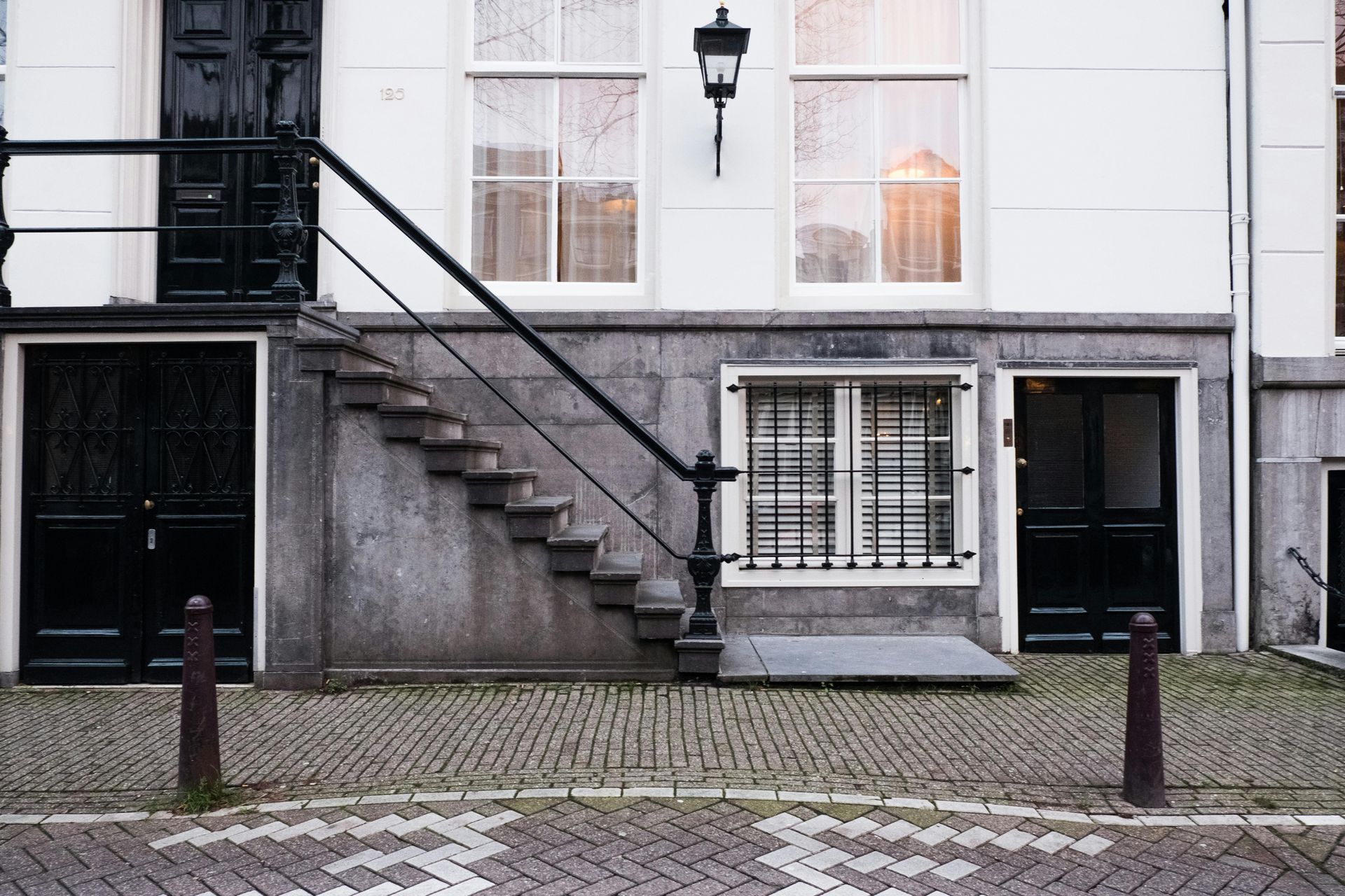 A white building with black doors and stairs