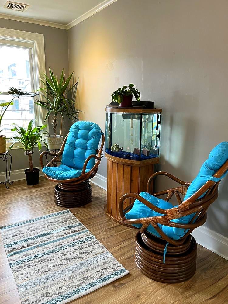 A living room with two chairs and a fish tank.