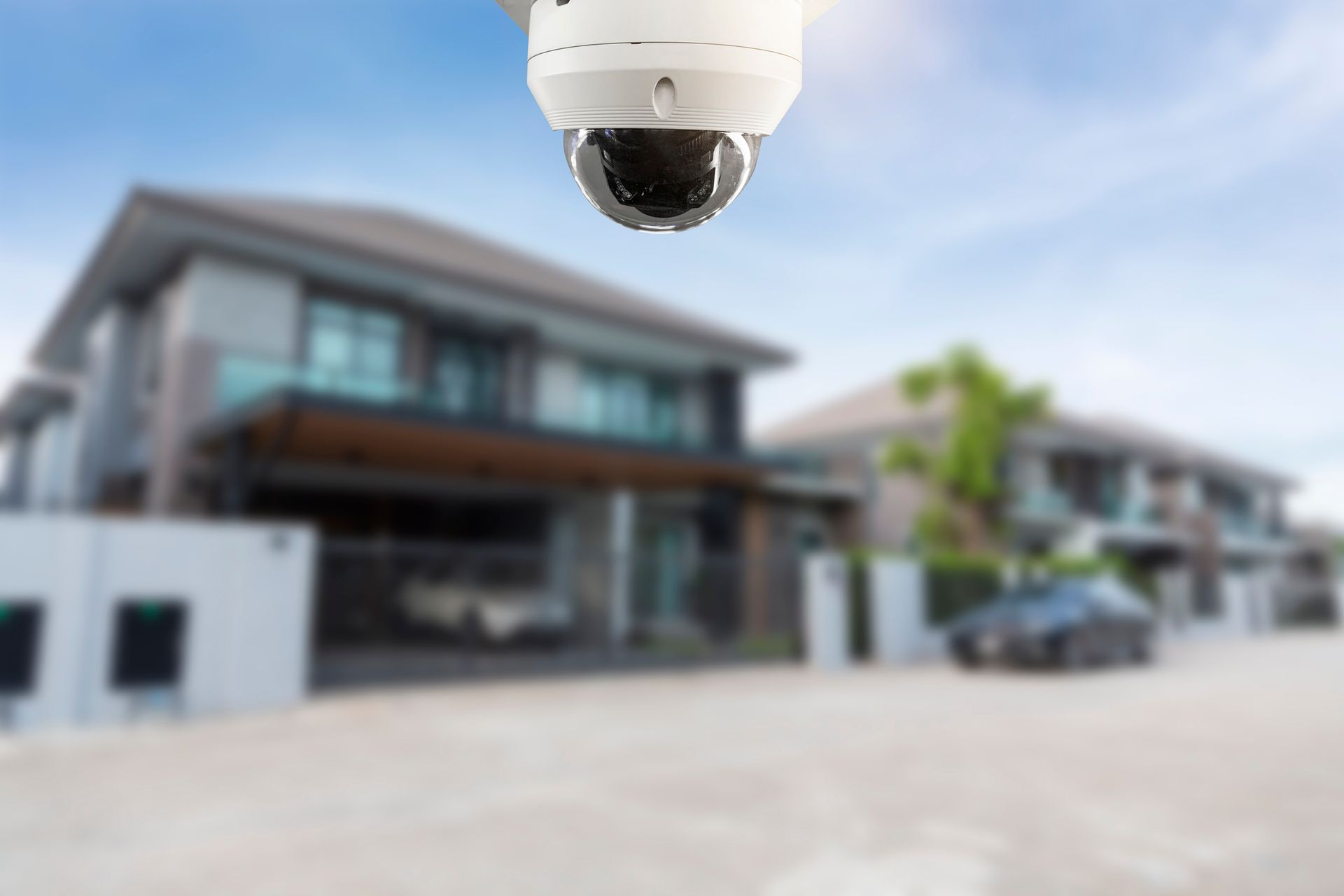Una telecamera di sicurezza è appesa al soffitto di fronte a una casa.