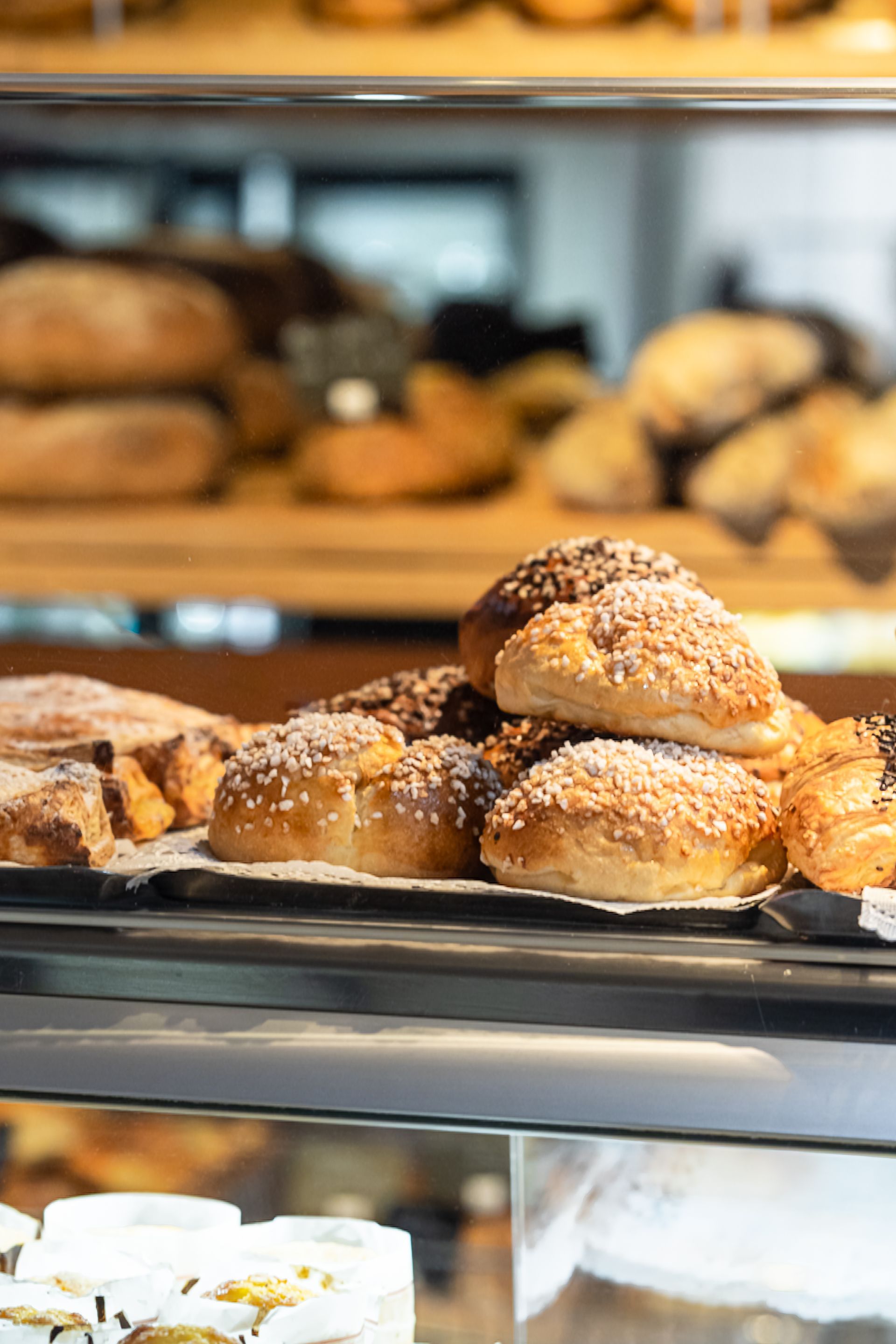 Plateau de petits pains au sésame sur une étagère de boulangerie