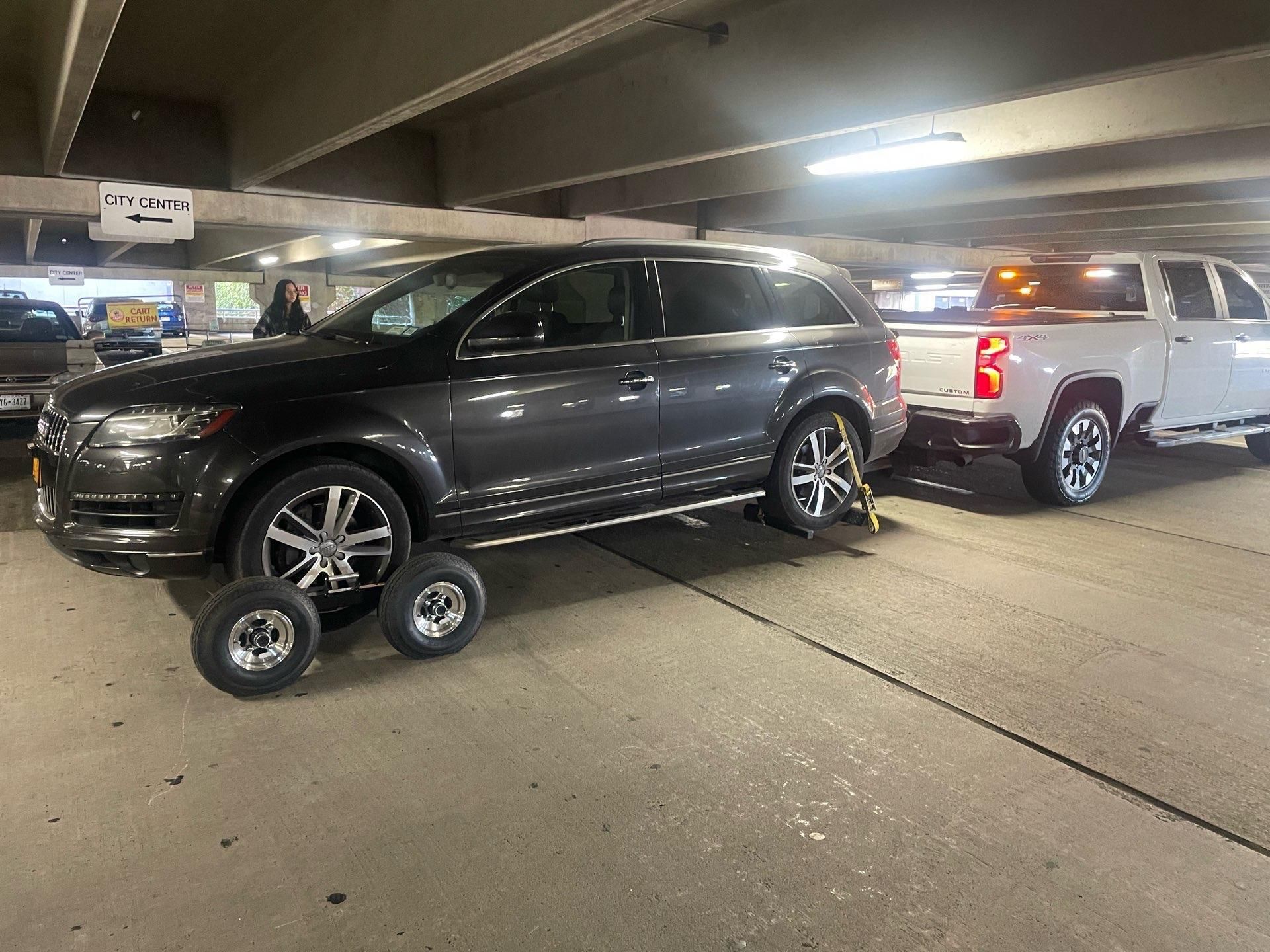 White car being loaded onto a tow truck on a roadside, silver ramp visible. White car being loaded onto a tow truck on a roadside, silver ramp visible.