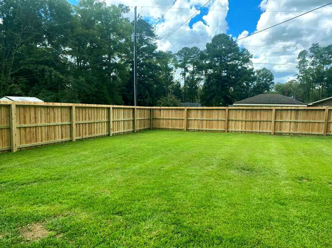 Wood privacy fence around a green residential backyard