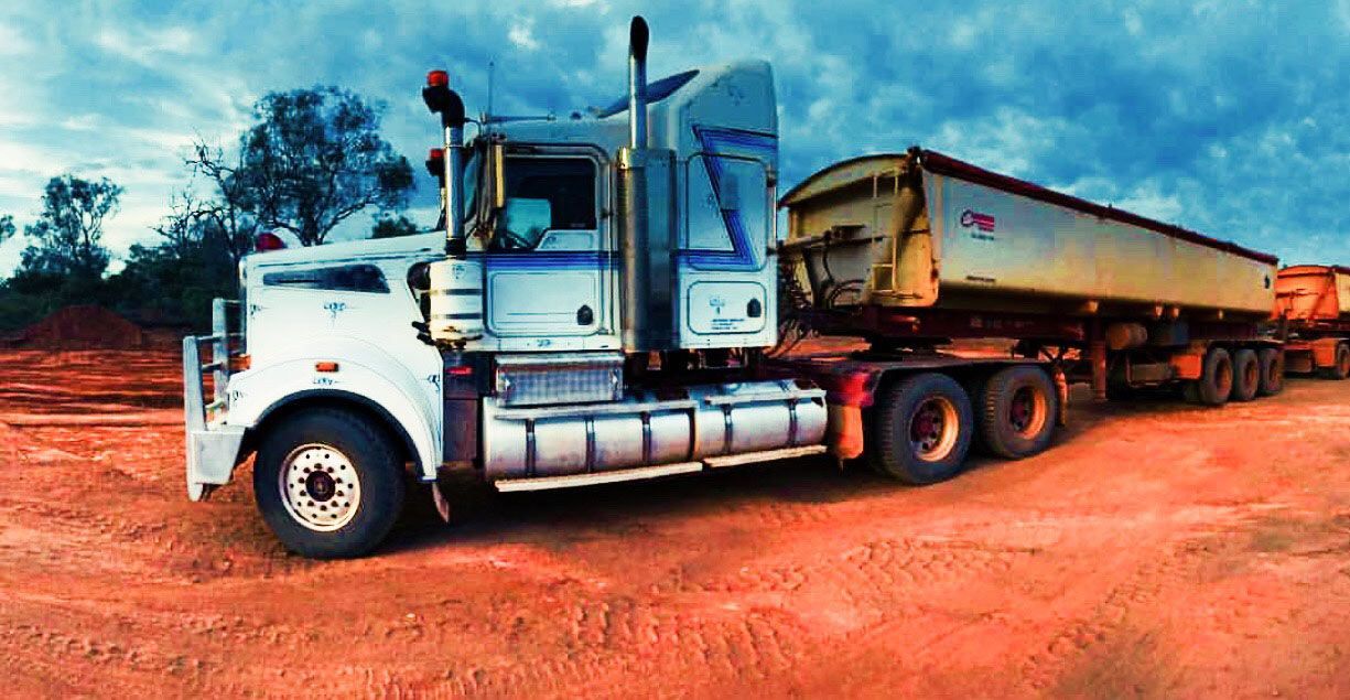 A Large Semi Truck Is Parked In The Field With Large Trailer — Coleman's Contracting & Earthmoving In Humpty Doo, NT