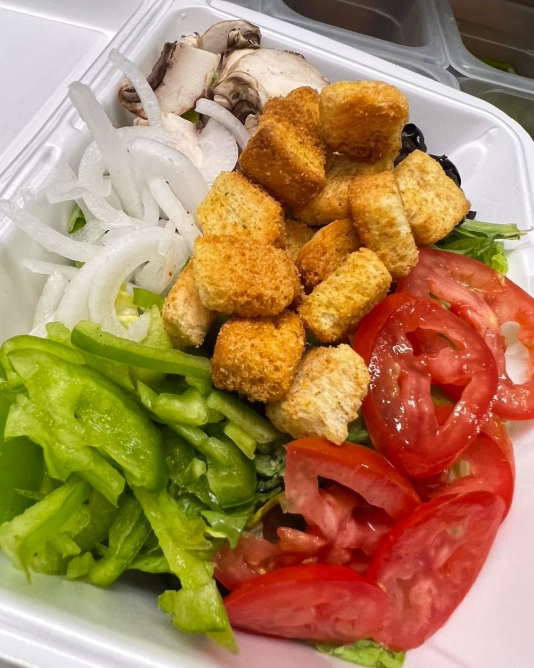 Salad bowl with green peppers, tomatoes, onions, mushrooms, and seasoned tofu cubes