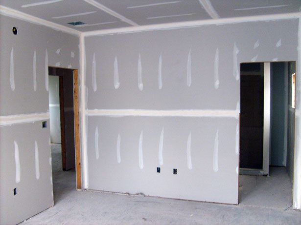 Interior room showing freshly hung drywall panels and seams.