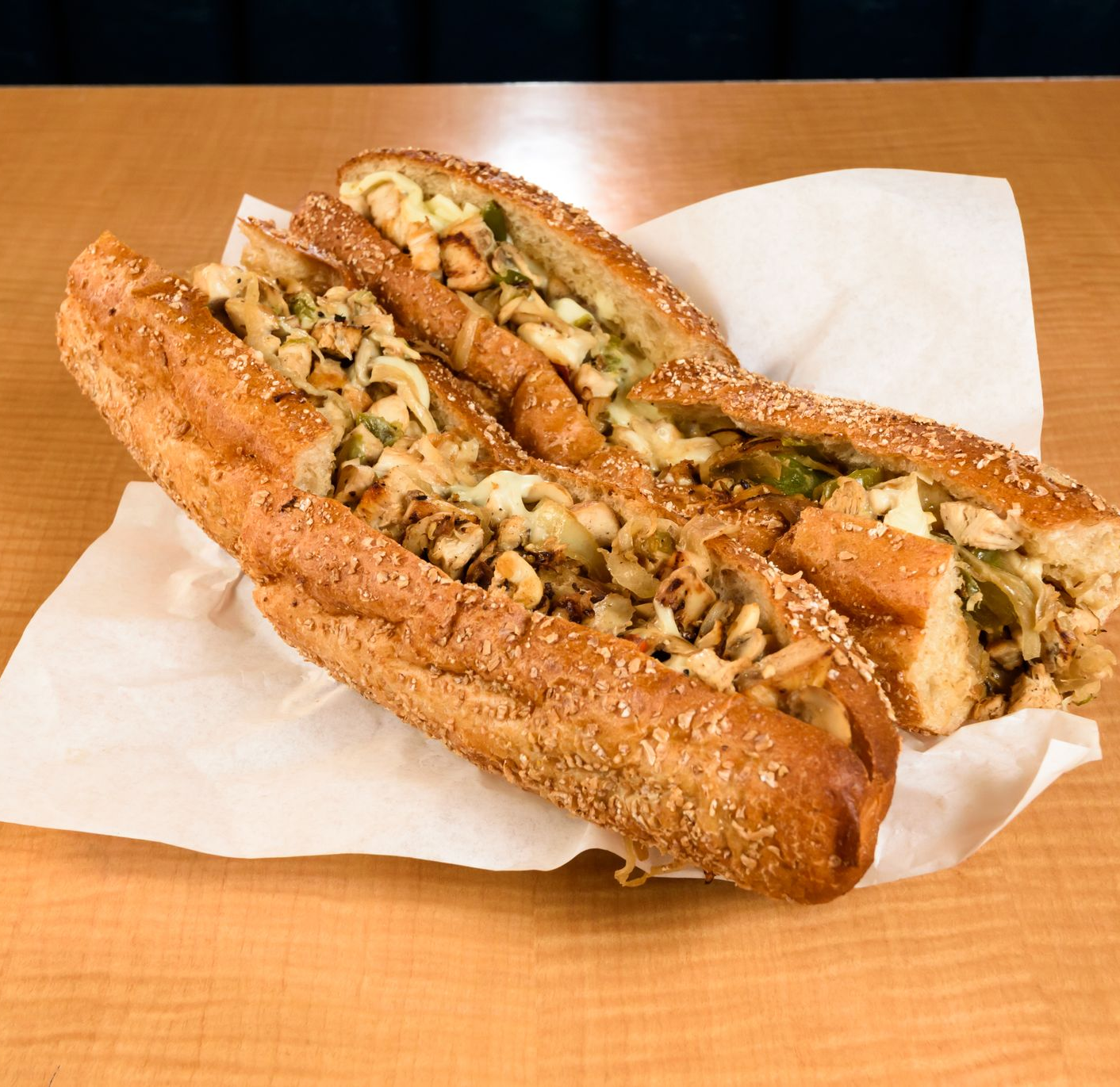 Two toasted sandwiches on white napkins on a wooden table