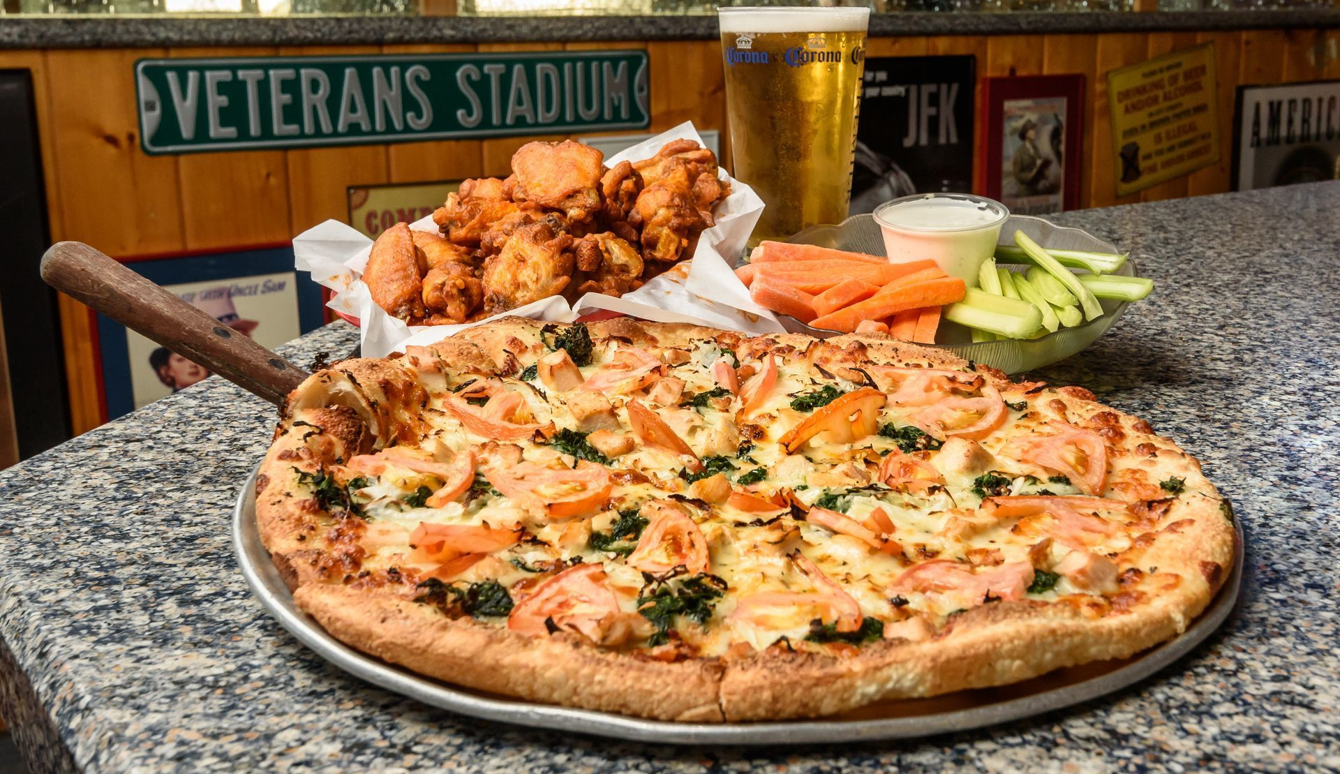 Pizza and fried chicken on a table at Veterans Stadium, with celery and carrots in the background