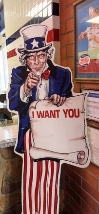 Uncle Sam cutout holding a “I WANT YOU” sign in an ice cream shop doorway