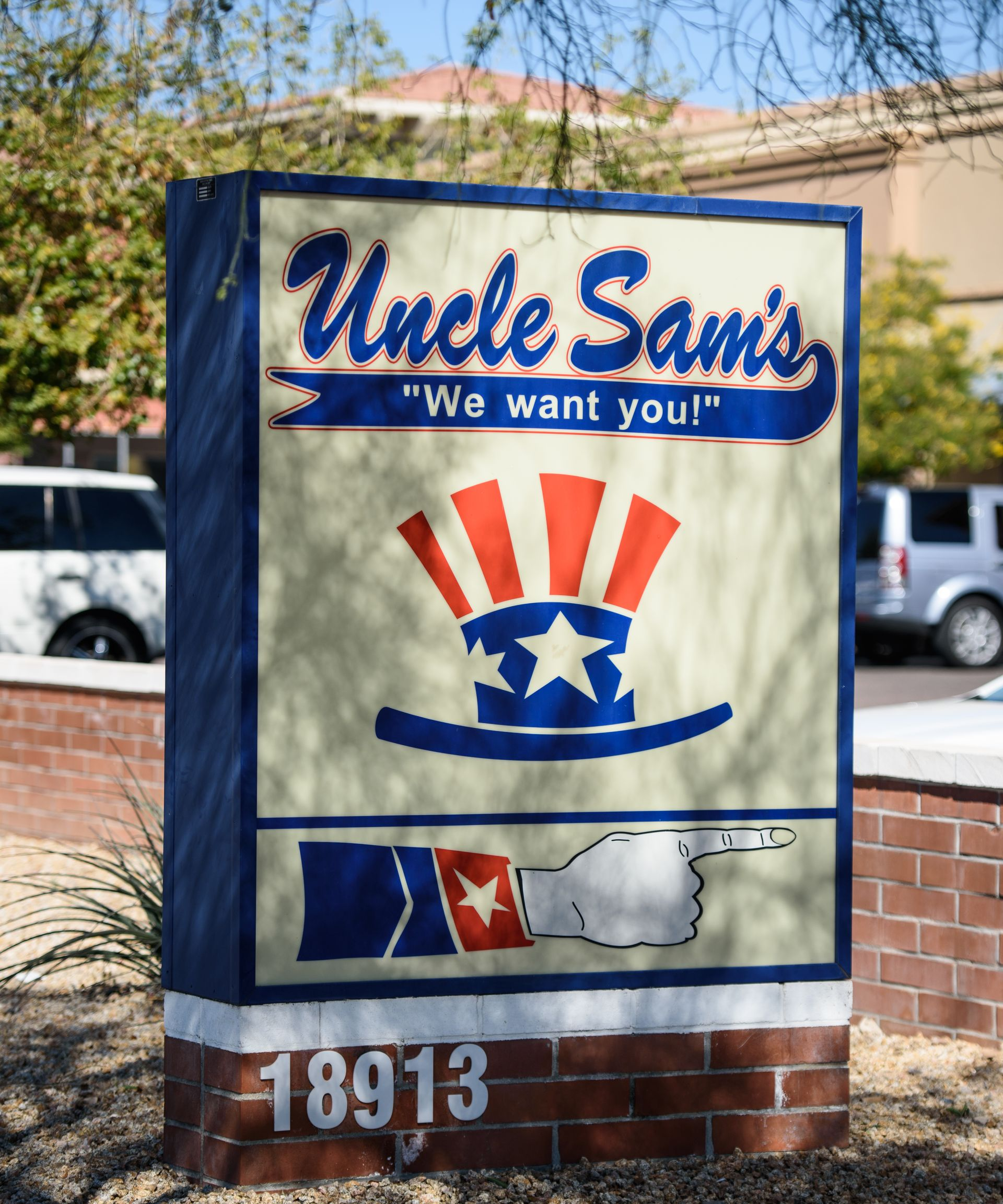 “Uncle Sam’s” restaurant sign with patriotic stars and stripes on a brick base.