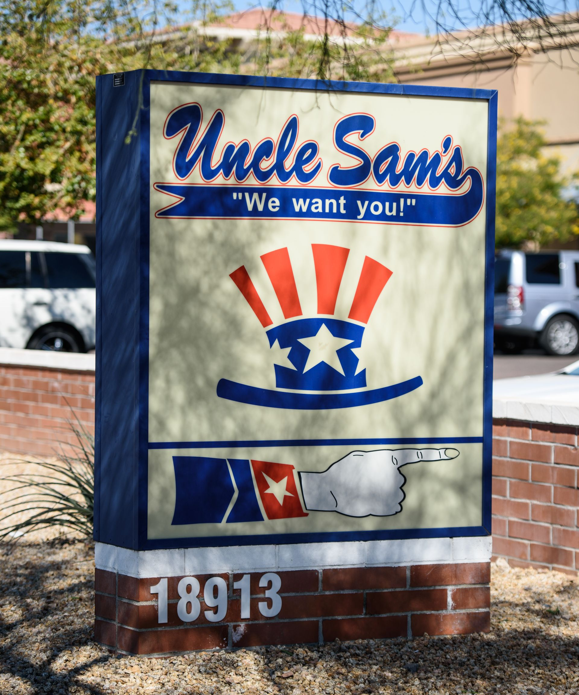 “Uncle Sam’s” restaurant sign on a brick base, with a patriotic red, white, and blue logo.