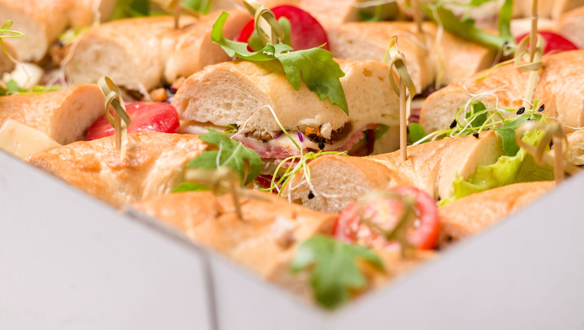 Open box of pizza topped with chicken, greens, and red peppers