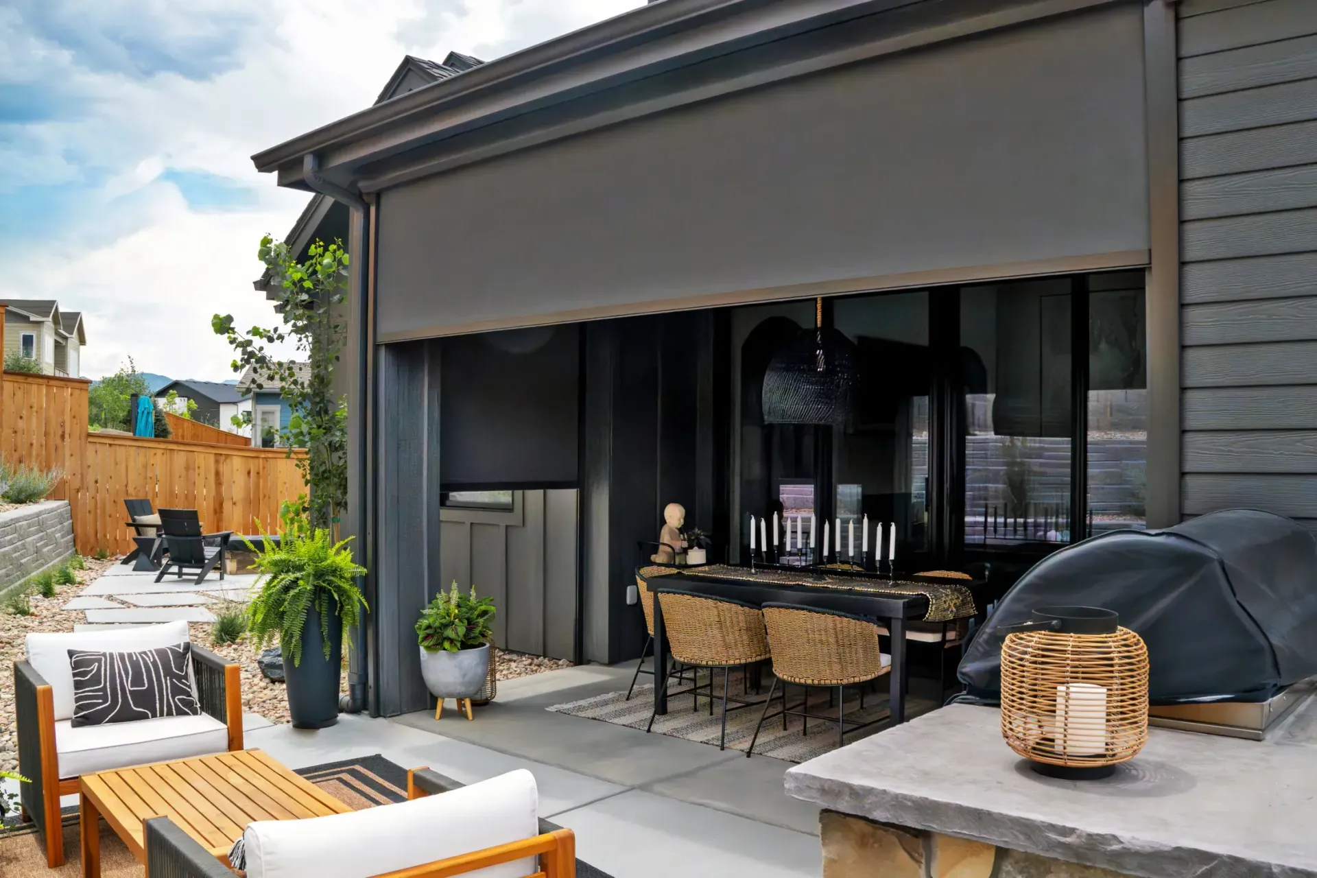 Outdoor patio with gray retractable awning, seating area with table and chairs.