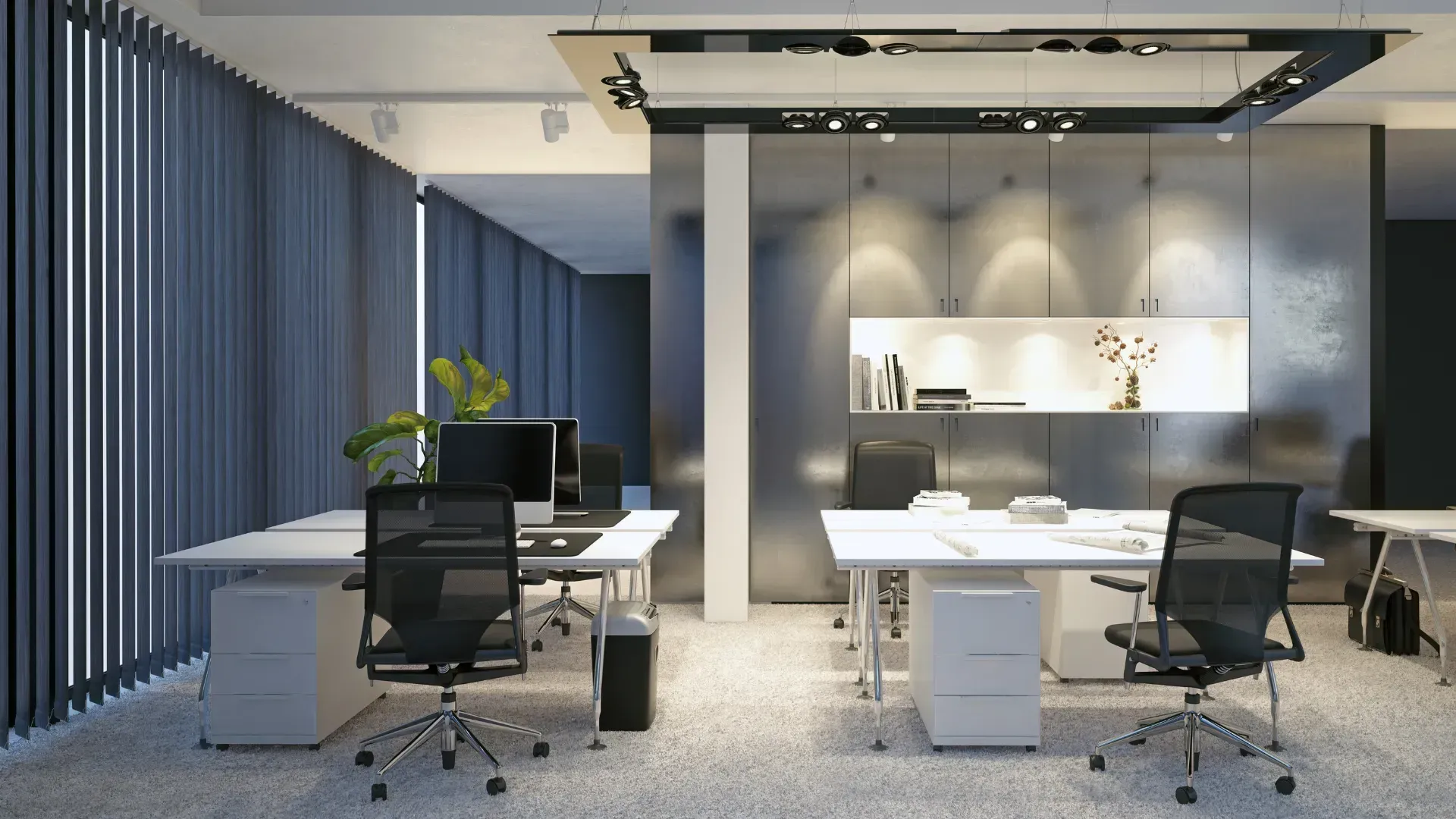 Modern office space with desks, chairs, and overhead lighting. Dark curtains and a neutral color scheme.