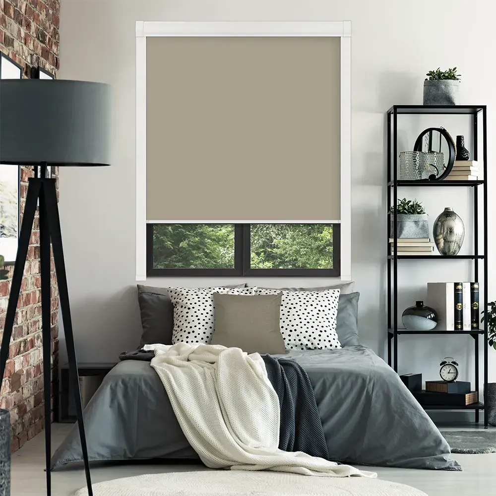 Bedroom with bed, window shades, bookshelf, lamp, and exposed brick wall.