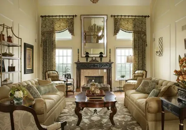Elegant living room with beige sofas, floral curtains, fireplace, and ornate furniture.