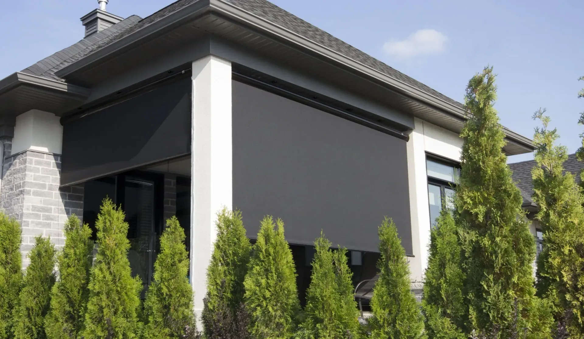 Black outdoor roller shades on a covered patio, installed by Blinds at Home