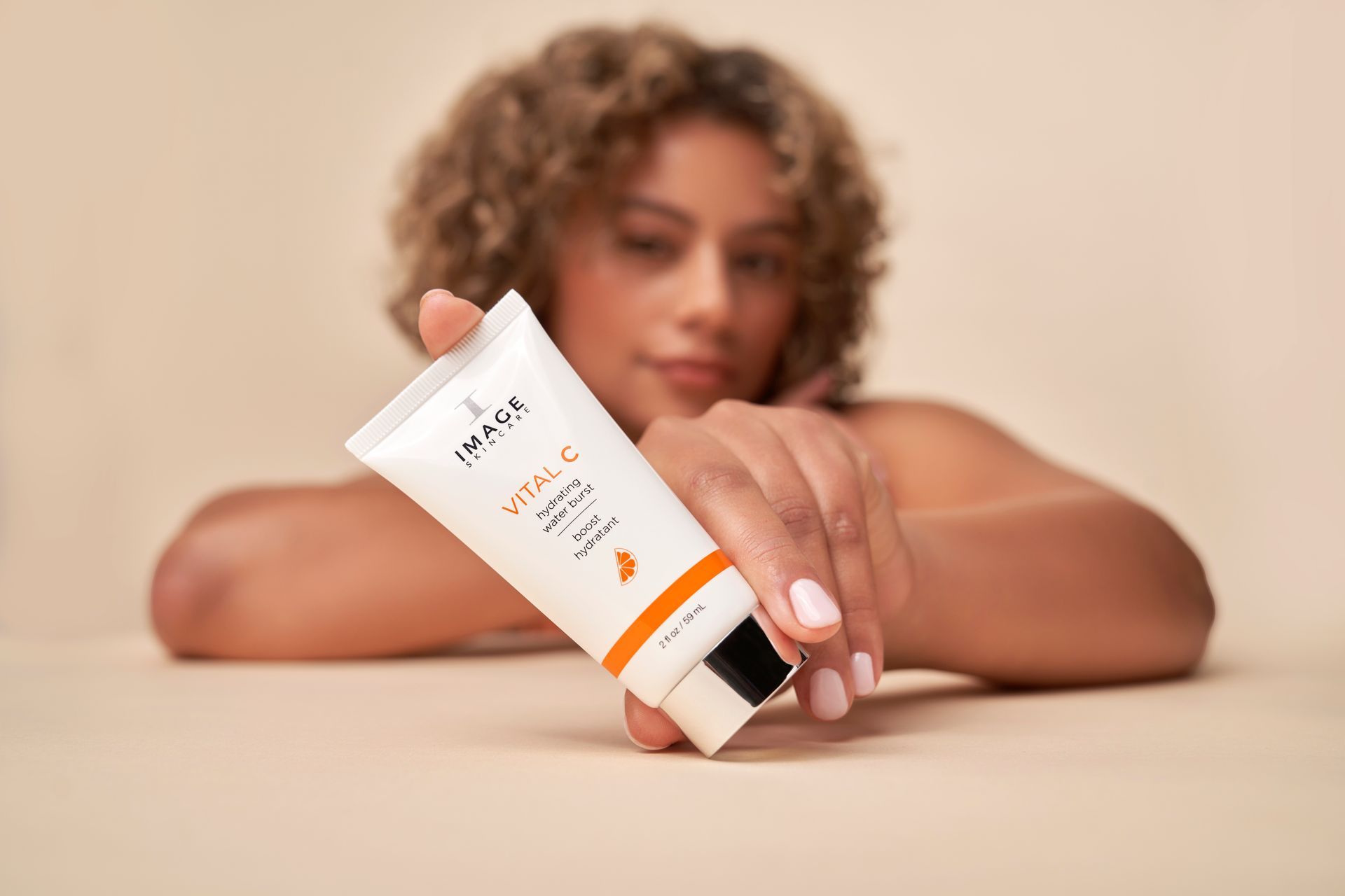 Woman holding a white tube of 