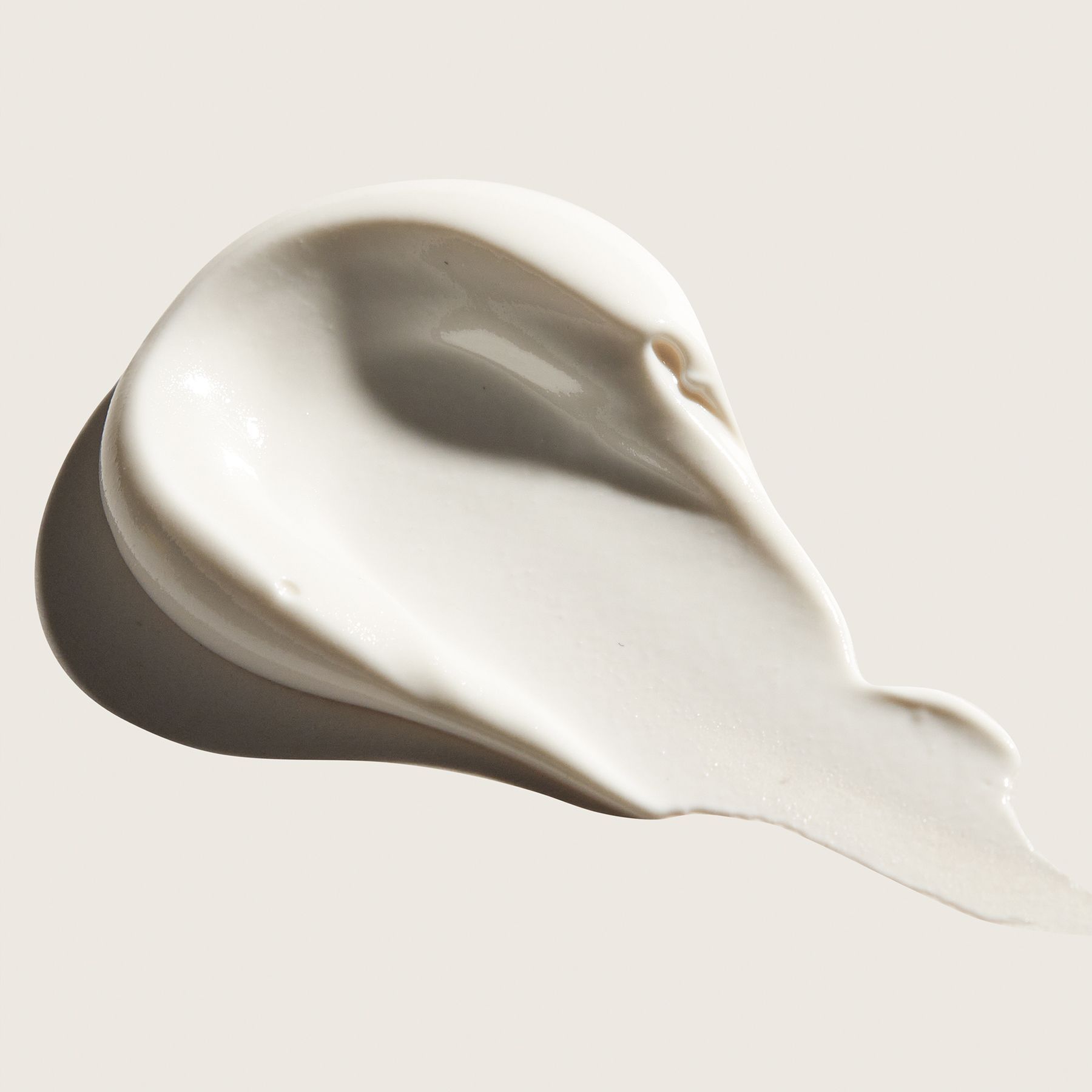 Swirled white cream with glossy highlights and a shadow.