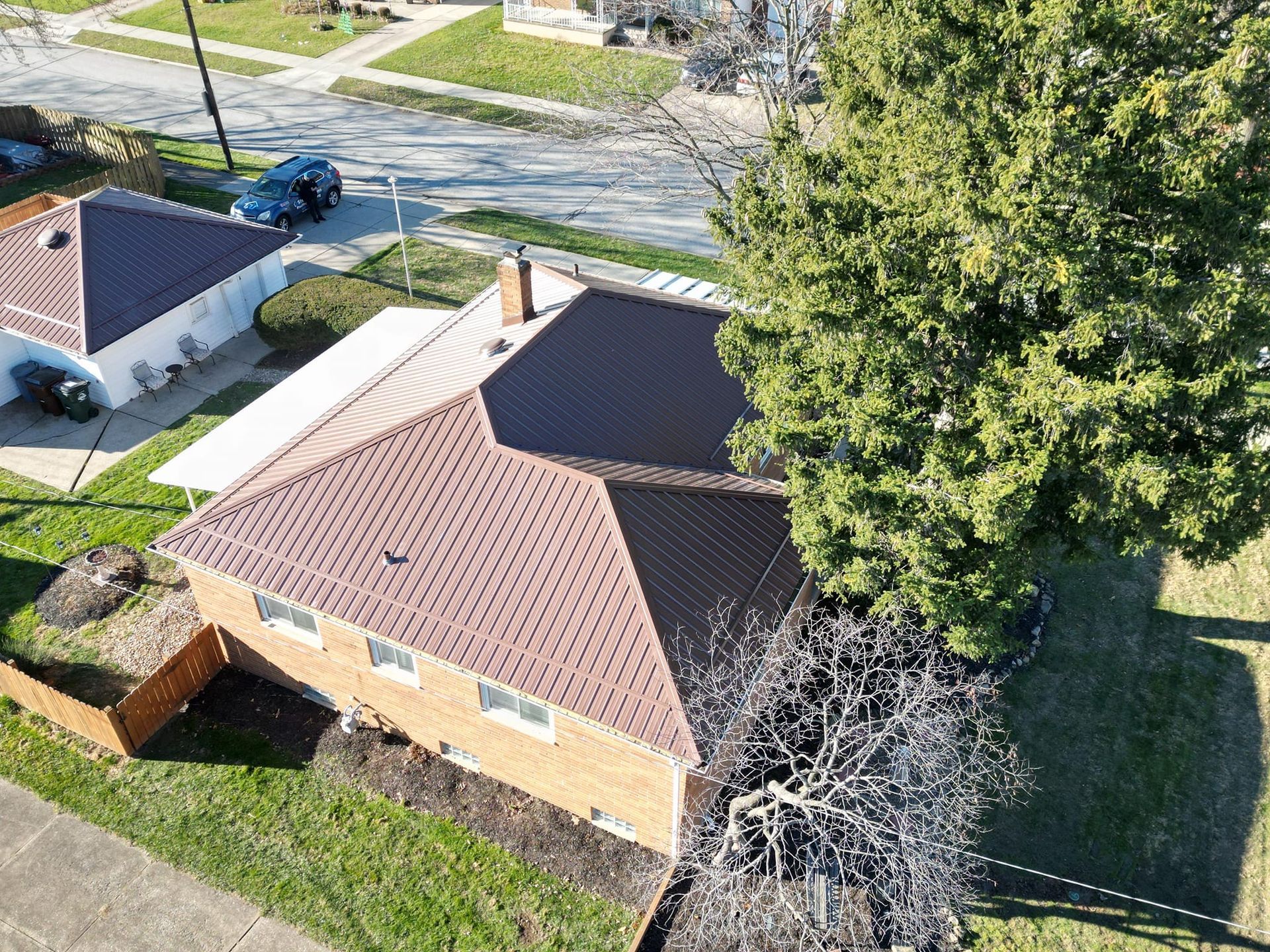 Aerial view of a brick house with a brown roof 