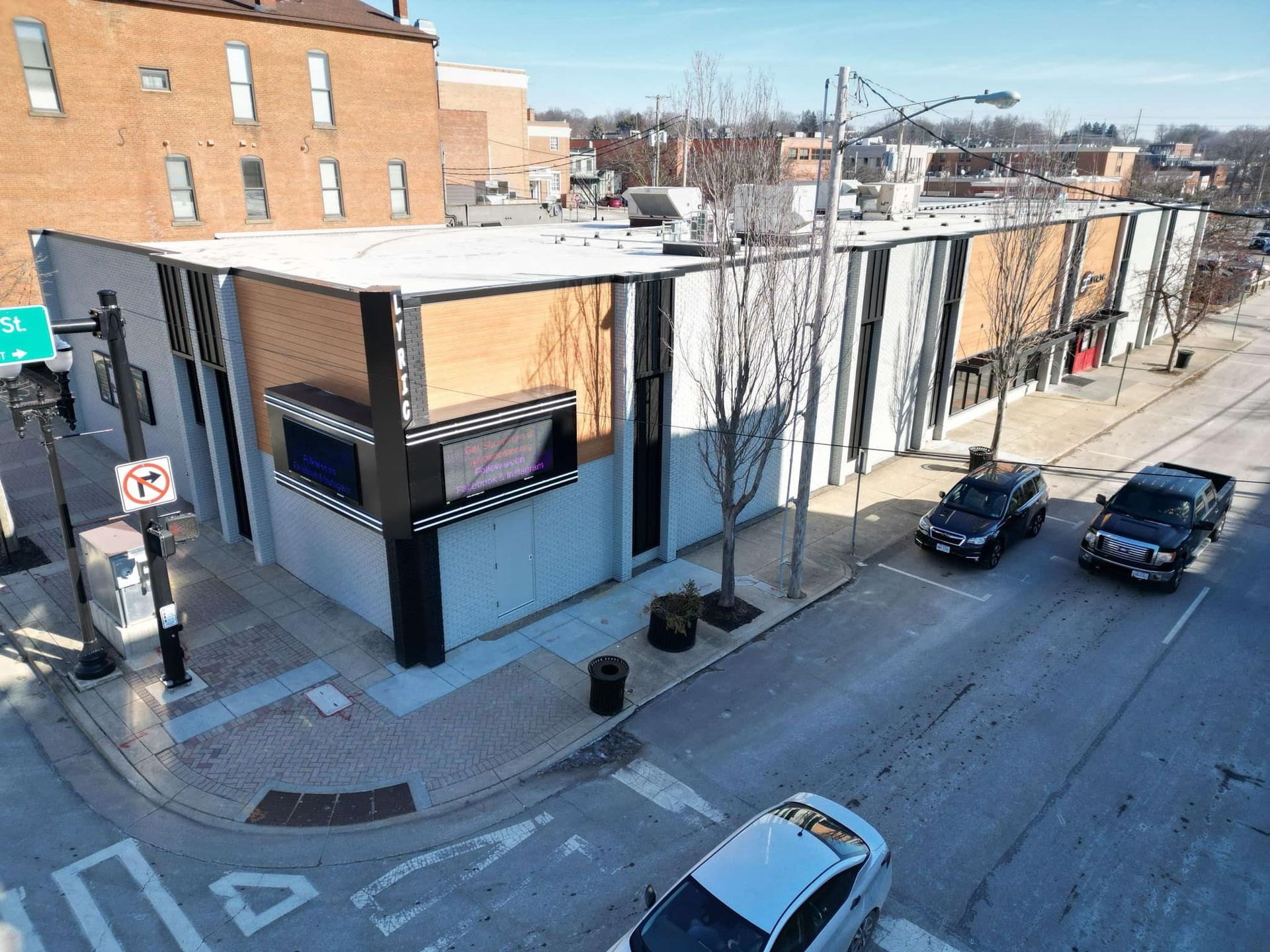 Exterior view of a modern building with black and tan facade, likely a movie theater.