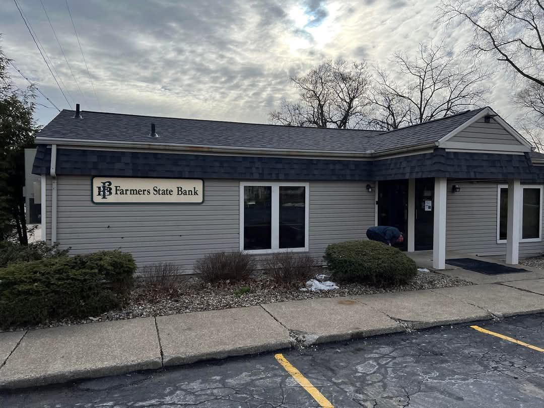 Exterior of the Farmers Trust Bank building on a cloudy day, with a person near the entrance. 