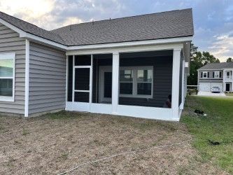 Screened porch addition on a gray house with white trim.