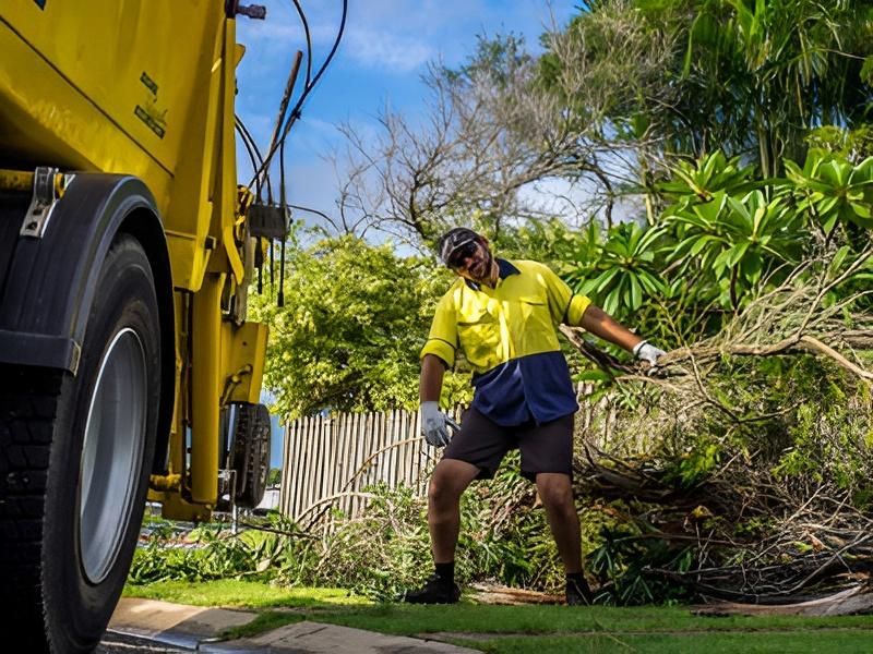 Garbage Truck Near Worker in Yellow Shirt, Loading Branches — Bobs Bags & Bins in Mackay, QLD