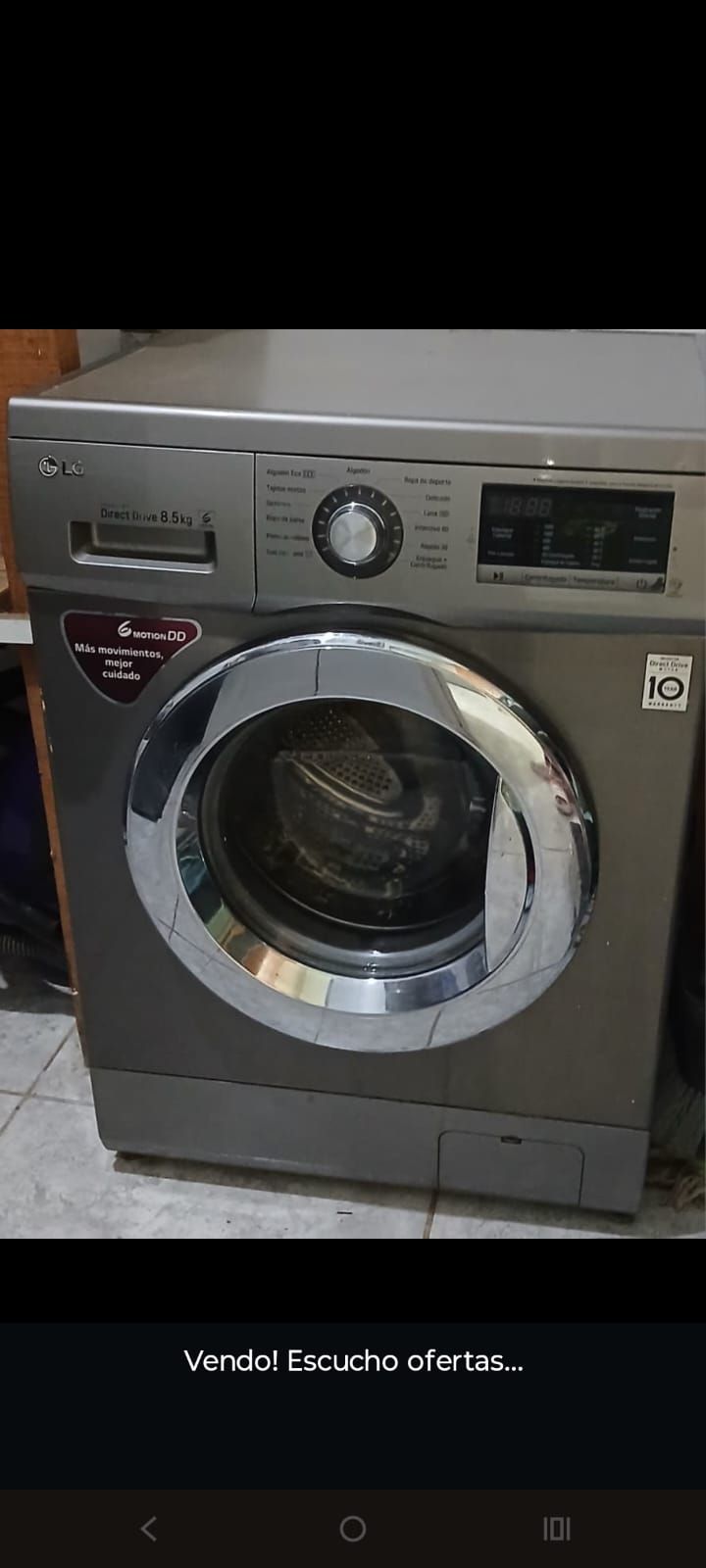 Técnico reparando una lavadora de carga frontal con la puerta abierta.
