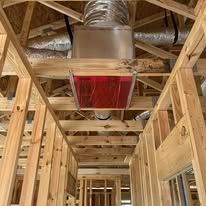 Framed ceiling with ventilation system, showing ducts and red filter, in a partially constructed building.