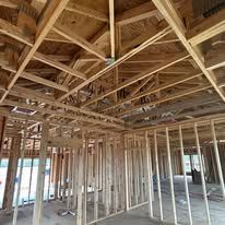 Wooden framework of a building under construction. Beams and studs create a roof and walls.