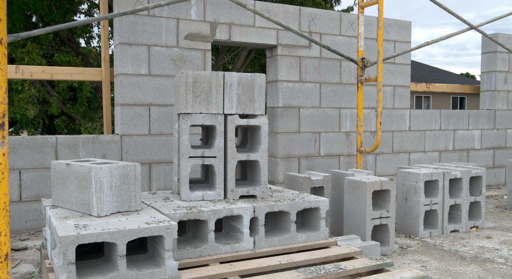 Concrete block wall being built with stacked cinder blocks and construction materials nearby during a block and retaining wall service in Santa Ana, CA