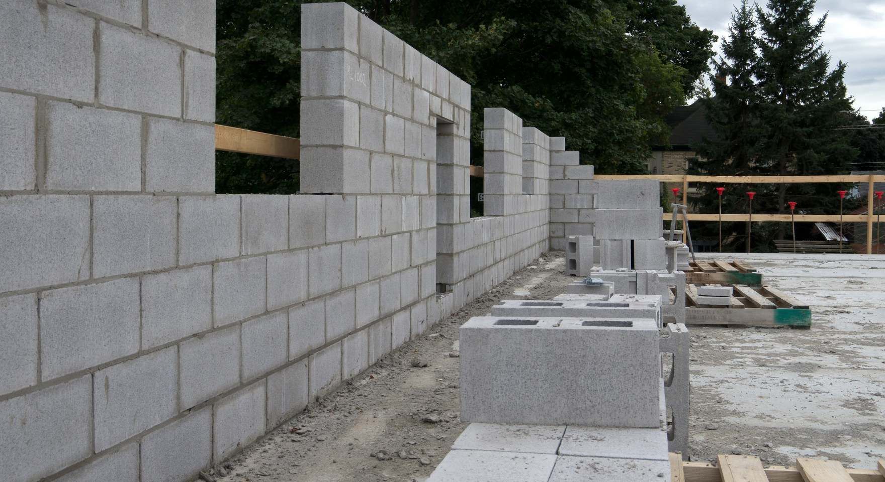 “Unfinished concrete block wall under construction with stacked blocks and open sections during a block and retaining wall service in Santa Ana, CA”