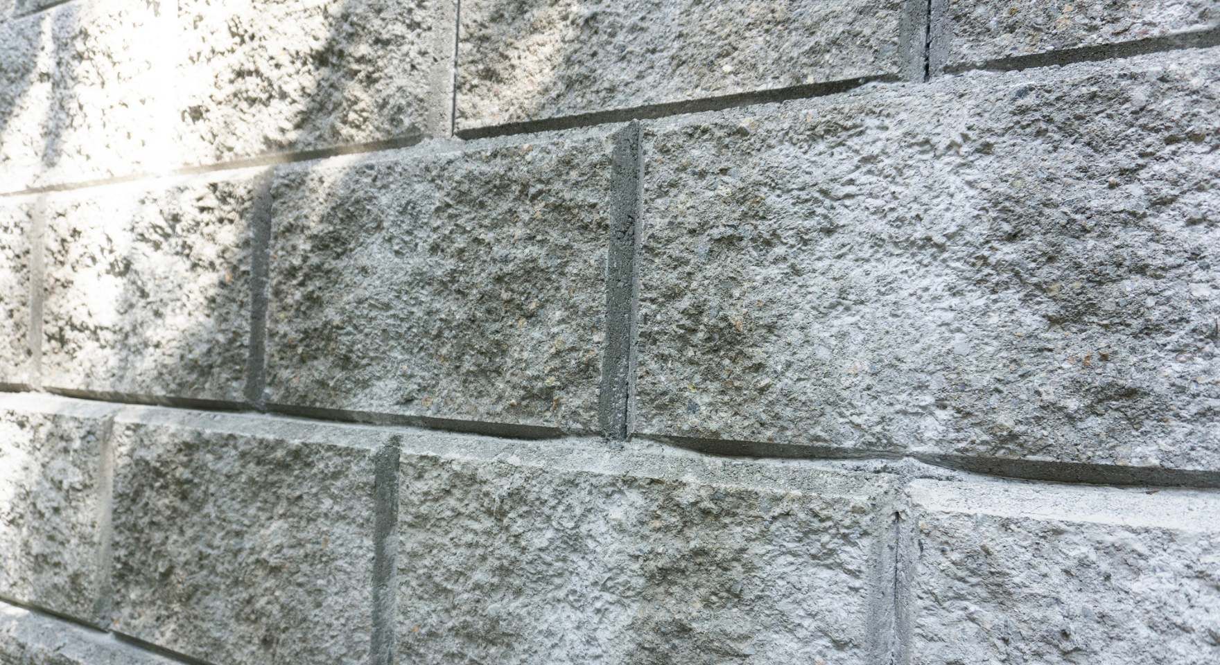 “Close-up of a gray concrete block wall showing rough texture and clean mortar lines during a block and retaining wall service in Santa Ana, CA”