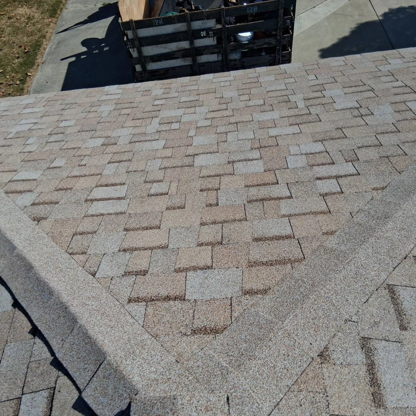 Brick-paved walkway leading to a black metal gate, viewed from above