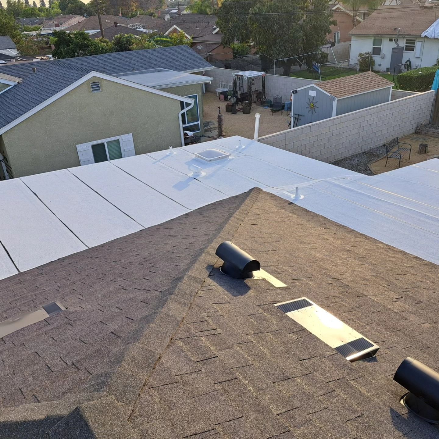 Rooftop solar panel installation on a brown shingle roof in a suburban neighborhood