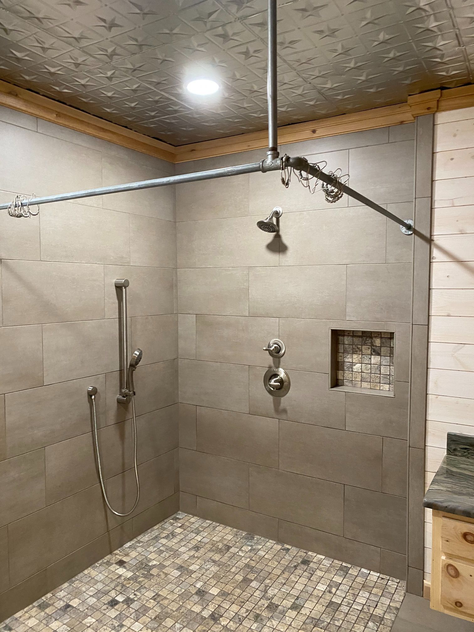 A bathroom with a walk in shower and a tiled floor.