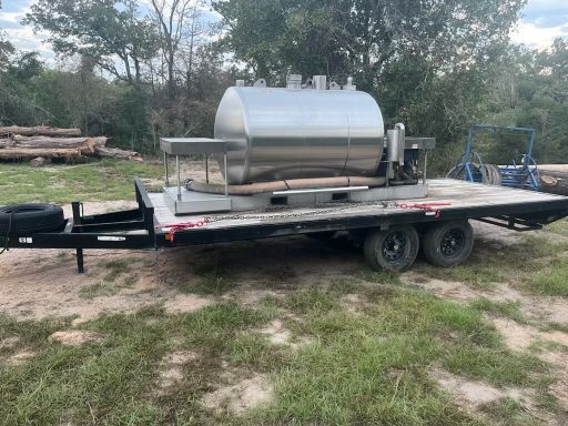 A stainless steel tank is sitting on top of a trailer.