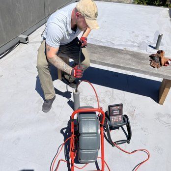 A man is working on a pipe with a camera attached to it.
