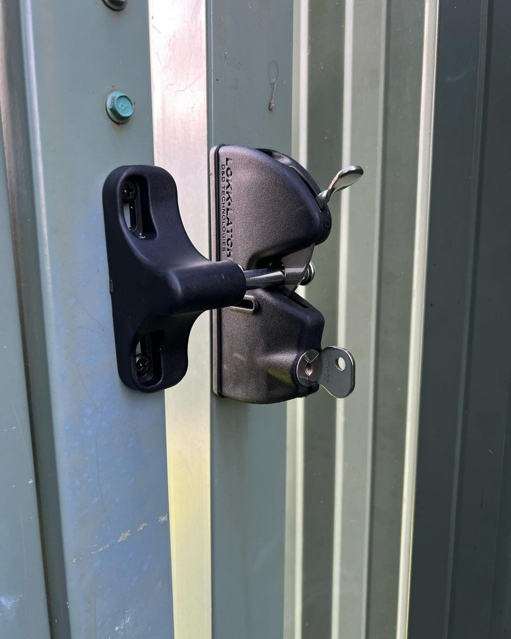 A Close Up of a Gate Lock With a Key Attached to It — JOA - Construction & Maintenance Pty Ltd in Appin, NSW