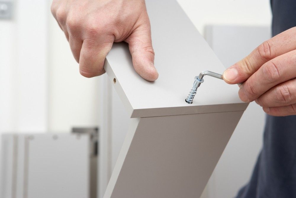 A Person is Screwing a Screw Into a Piece of Wood — JOA - Construction & Maintenance Pty Ltd in Appin, NSW