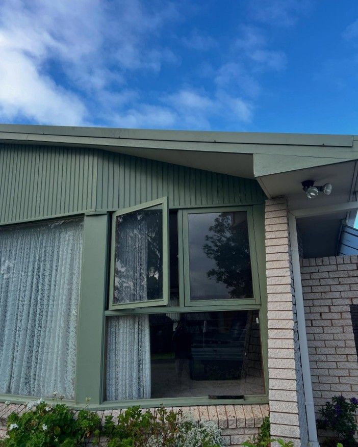 A Brick House With a Green Roof and a Large Window — JOA - Construction & Maintenance Pty Ltd in Appin, NSW