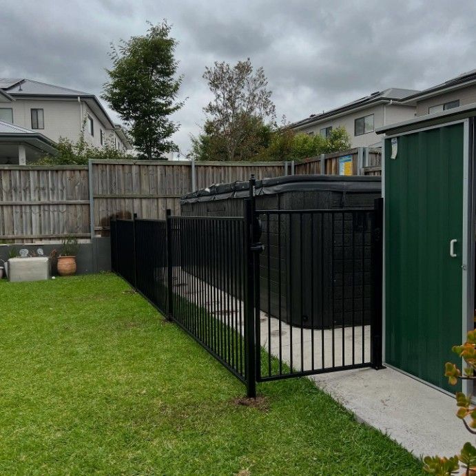 A Backyard With a Black Fence and a Green Shed — JOA - Construction & Maintenance Pty Ltd in Appin, NSW