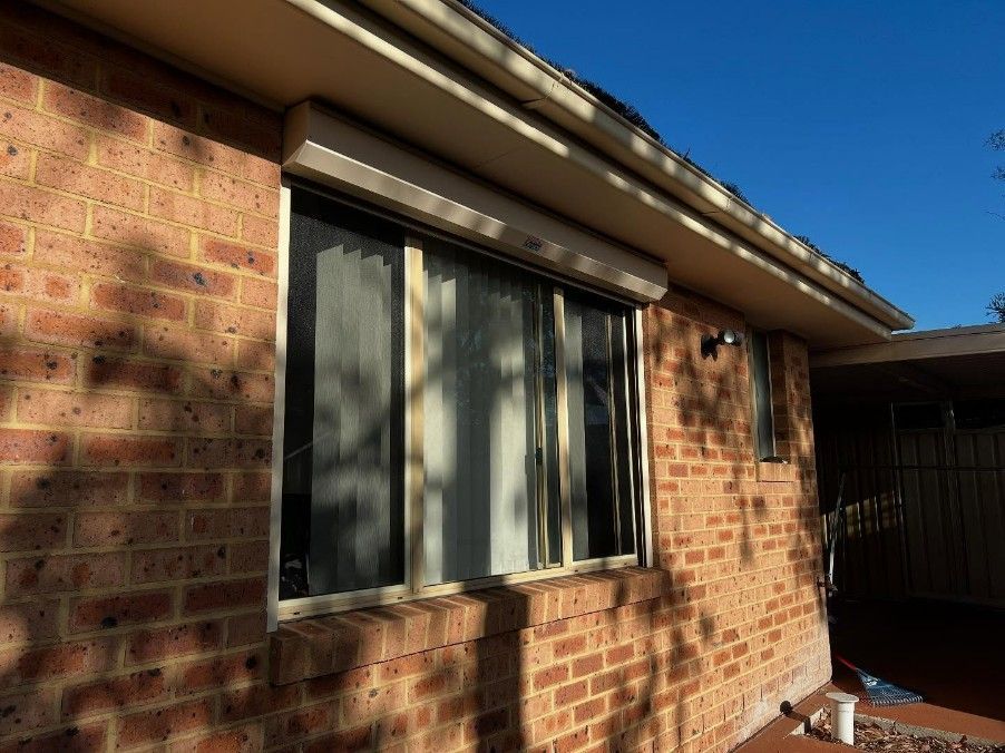 A Brick House With a Large Window on the Side — JOA - Construction & Maintenance Pty Ltd in Narellan, NSW
