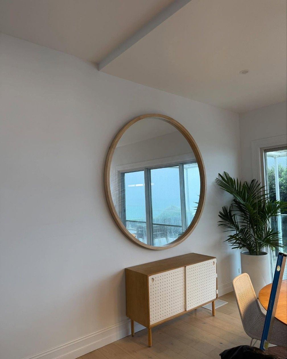 A Large Round Mirror is Hanging on a White Wall — JOA - Construction & Maintenance Pty Ltd in Albion Park, NSW