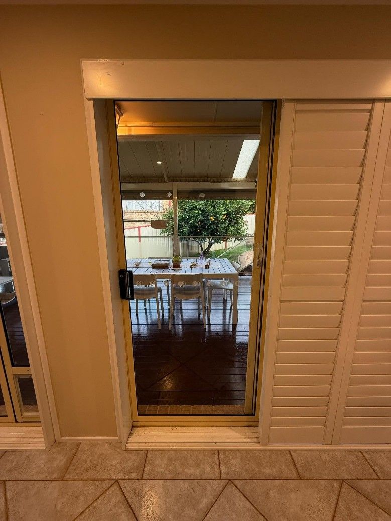 A Sliding Glass Door Leading to a Dining Room — JOA - Construction & Maintenance Pty Ltd in Campbelltown, NSW