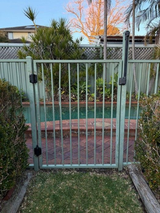 A Gate Leading to a Swimming Pool in a Backyard — JOA - Construction & Maintenance Pty Ltd in Appin, NSW